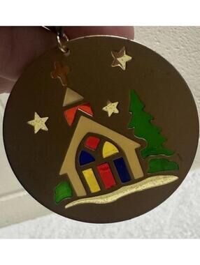Brass colored Christmas ornaments with colored cut out that shine in the light